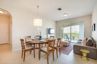 a dining room and living room with a table and chairs at Cozy Condo wPrivate Balcony & FREE Resort Access in Orlando