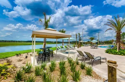 a pavilion with chairs and tables next to a pool at 4814 Lullaby Lane in Kissimmee