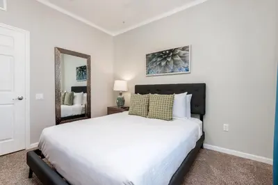 a bedroom with a large white bed and a mirror at Beautiful Vista Cay Condo, Near I-Drive in Orlando