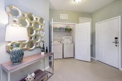 a living room with a large mirror on the wall at Beautiful Vista Cay Condo, Near I-Drive in Orlando