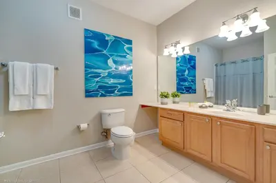 a bathroom with a toilet and a sink and a mirror at Breakview Fun & Sun in Orlando
