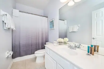 a white bathroom with a sink and a toilet at Updated Vista Cay Townhome, 10 min from Universal in Orlando