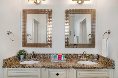 a bathroom with two sinks and two mirrors at Updated Condo Near Conv Ctr, I-Drive & Universal in Orlando