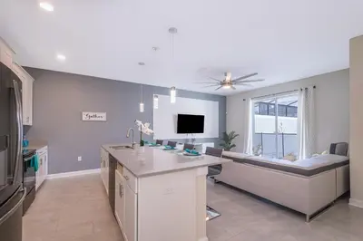 a kitchen with a sink and a desk with a tv at 4834BV TOWNHOUSE 4 BEDROOMS & 3 BATHROOMS + POOL in Kissimmee