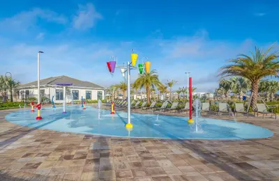 a pool with water fountains in a parking lot at 4834BV TOWNHOUSE 4 BEDROOMS & 3 BATHROOMS + POOL in Kissimmee
