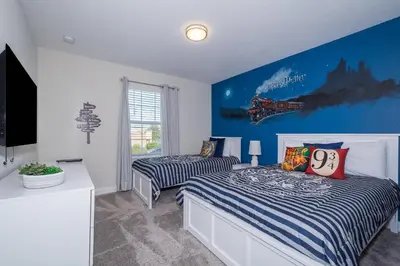 a bedroom with two beds and a blue wall at 4993FP TOWNHOUSE 4 BEDROOMS & 3 BATHROOMS + POOL in Kissimmee
