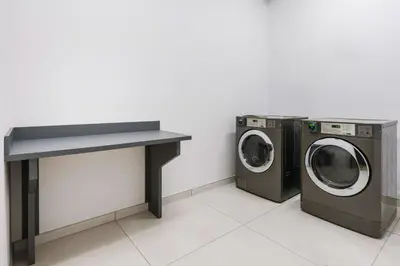 two washing machines and a table in a room at Hilton Garden Inn Apopka City Center, Fl in Orlando