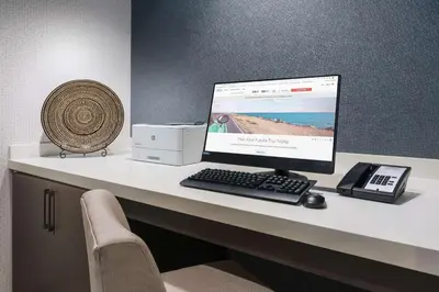 a desk with a computer and a fan on it at Hilton Garden Inn Apopka City Center, Fl in Orlando
