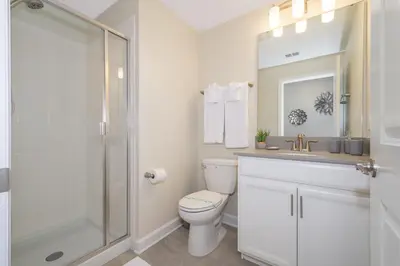 a bathroom with a toilet and a sink and a shower at 4975AN TOWNHOUSE 5 BEDROOMS & 4 BATHROOMS + POOL in Kissimmee