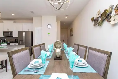a dining room with a table with blue napkins at Luxurious Décor 4 Bd w/ Pool Close to Disney 4820 in Kissimmee