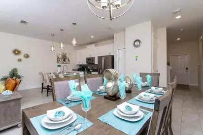 a dining room and kitchen with a table and chairs at Luxurious Décor 4 Bd w/ Pool Close to Disney 4820 in Kissimmee