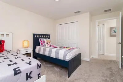 a bedroom with a bed with black and white sheets at Luxurious Décor 4 Bd w/ Pool Close to Disney 4820 in Kissimmee