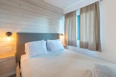 a bedroom with a bed with white sheets and a window at Deluxe Studio w/ Lakeview - free parking/pool in Orlando