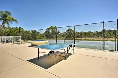 a tennis court with a table and a tennis racket at Family Home with Game Room 9 Mi to Disney World in Orlando