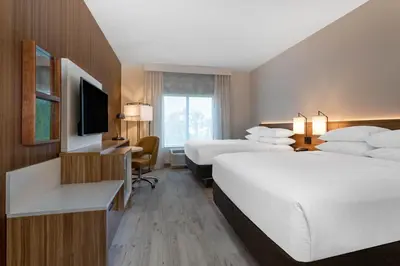 a hotel room with two beds and a television at Wyndham Garden Orlando Universal / I Drive in Orlando