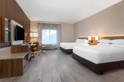 a hotel room with two beds and a flat screen tv at Wyndham Garden Orlando Universal / I Drive in Orlando