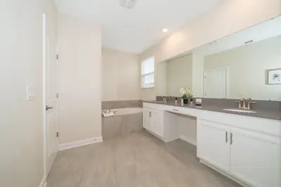 a white bathroom with a sink and a tub at 2744HM VILLA 5 BED/5 BA (SANITIZED) in Kissimmee