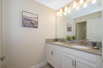 a bathroom with two sinks and a large mirror at 4964RS TOWNHOUSE 4 BEDROOMS & 3 BATHROOMS + POOL in Kissimmee