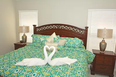 two swans sitting on top of a bed at 2685OL - Jagu Deaux (G) in Kissimmee