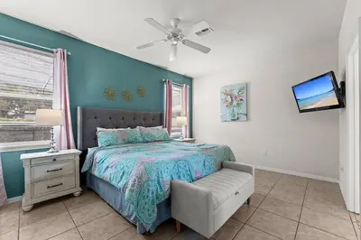 a bedroom with a bed with a chair and a tv at 1323ZUREIQ-Zureiq Dreams (S) in Orlando
