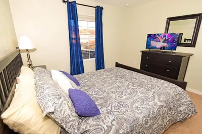 a bedroom with a bed and a dresser with a mirror at 8975CPR - Waites Home (G) in Kissimmee