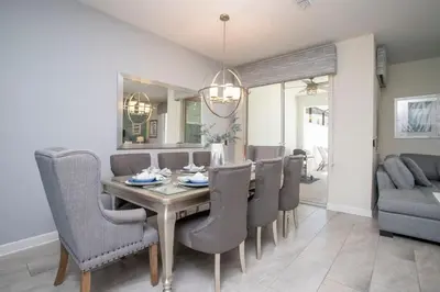 a dining room with a table and chairs at Ravishing Four Bd w/ Pool Close to Disney 4947 in Kissimmee