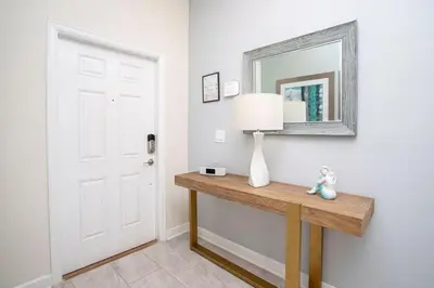 a room with a table with a lamp and a mirror at Ravishing Four Bd w/ Pool Close to Disney 4947 in Kissimmee