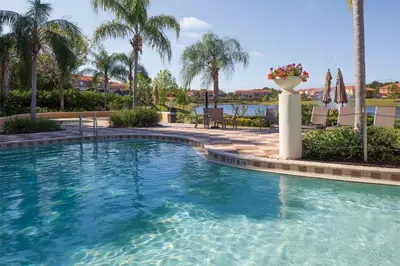 a swimming pool in a resort with palm trees at Encantada 3 Bedroom Townhome with Pool 2009 in Kissimmee