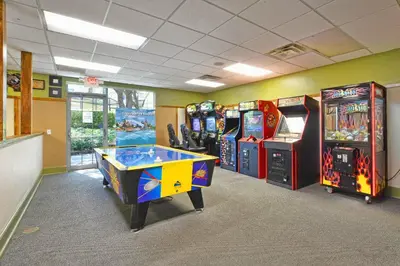 a room with several arcade games and a table at Encantada 3 Bedroom Townhome with Pool 2009 in Kissimmee