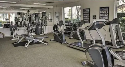 a gym with several treadmills and elliptical machines at Encantada 3 Bedroom Townhome with Pool 2009 in Kissimmee