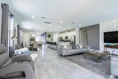 a living room with couches and a dining room and kitchen at Upscale Modern Getaway home with heated pool/hot tub, 9 beds 8.5 bath Sleeps 18+ in Orlando