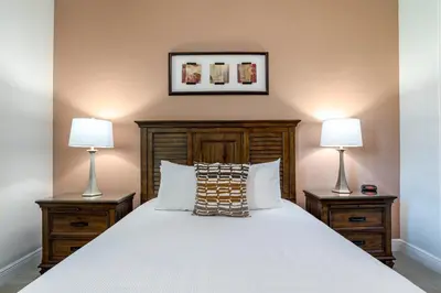 a bedroom with a white bed with two lamps at Upscale Modern Getaway home with heated pool/hot tub, 9 beds 8.5 bath Sleeps 18+ in Orlando