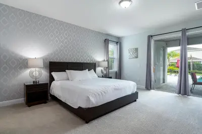 a bedroom with a bed and a large window at Upscale Modern Getaway home with heated pool/hot tub, 9 beds 8.5 bath Sleeps 18+ in Orlando