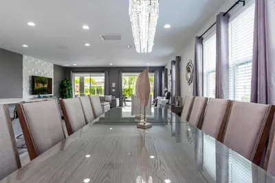 a dining room with a long table and chairs at Upscale Modern Getaway home with heated pool/hot tub, 9 beds 8.5 bath Sleeps 18+ in Orlando