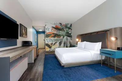 a hotel room with a bed and a flat screen tv at TRYP by Wyndham Orlando in Orlando