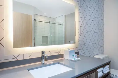 a bathroom with a sink and a mirror at TRYP by Wyndham Orlando in Orlando