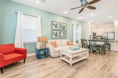 a living room with a couch and a table at Sanderella Castle! Premium Cottage With Private Hot Tub Near Disney With Margaritaville Resort & Island H2O Access - 3037Sp in Orlando