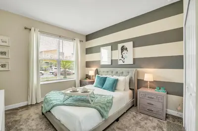 a bedroom with a bed with a striped wall at Storey Lake Resort 5 Bedroom Vacation Home with Pool 2307 in Kissimmee