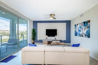 a living room with a white couch and a tv at 4731-206OR STOREY LAKE, CONDO 2/2 GARDEN VIEW in Kissimmee