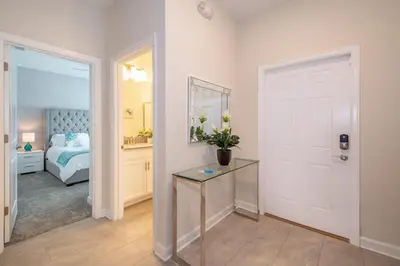 a bedroom with a bed and a table with flowers on it at 4819JA TOWNHOUSE 4 BEDROOMS & 3 BATHROOMS + POOL in Kissimmee