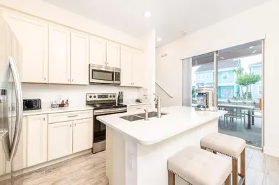 a kitchen with white cabinets and a large window at Fabulous Cottage Near Disney With Margaritaville Resort & Island H2O Access - 8075Kd in Orlando