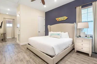 a bedroom with a white bed and a blue wall at Celestial Cottage Near Disney With Margaritaville Resort & Island H2O Access - 8036Dr in Orlando