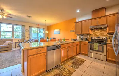 a kitchen with wooden cabinets and stainless steel appliances at 4 Bedroom SunHaven Townhouse with Pool Near Disney in Kissimmee