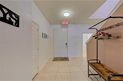 a hallway with white walls and a white door at 4 Bedroom SunHaven Townhouse with Pool Near Disney in Kissimmee