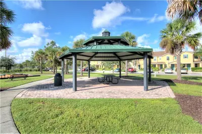 a picnic shelter in a park with palm trees at 4 Bedroom SunHaven Townhouse with Pool Near Disney in Kissimmee