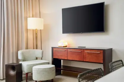 a room with a tv and a chair and a desk at TownePlace Suites by Marriott Orlando Downtown in Orlando