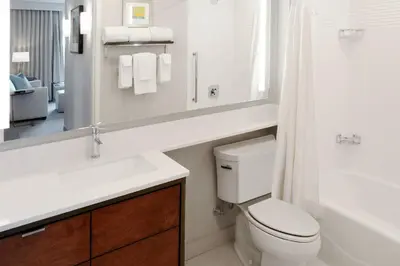 a bathroom with a toilet and a sink and a mirror at TownePlace Suites by Marriott Orlando Downtown in Orlando