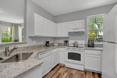 a kitchen with white cabinets and white appliances at 2 Bedroom Vacation Condo 2011 in Kissimmee