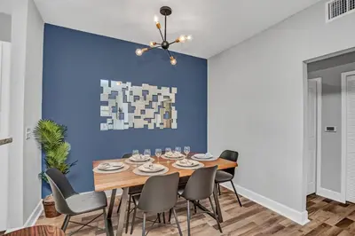a dining room with a blue wall and a wooden table and chairs at 2 Bedroom Vacation Condo 2011 in Kissimmee