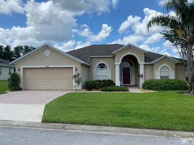 a house with a garage and a palm tree at Platinum Vacation Homes of Orlando in Orlando